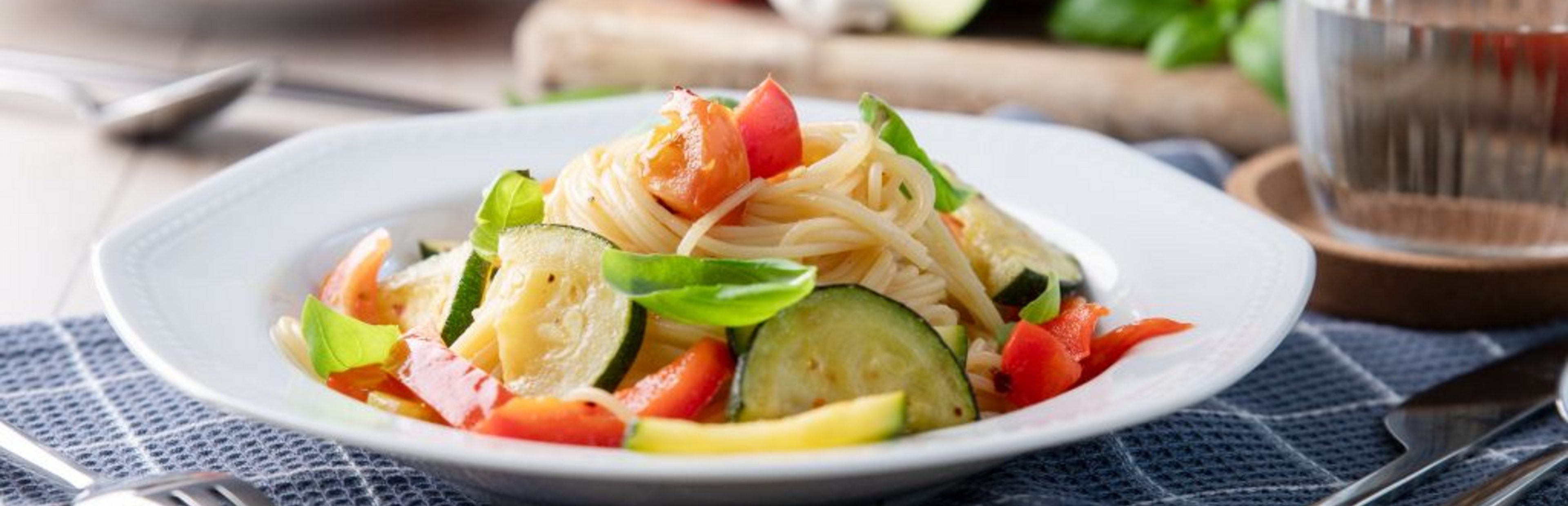 Sommerpasta: Spaghettini mit frischem Fruchtgemüse, angerichtet auf einem tiefen Teller