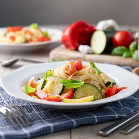 Sommerpasta: Spaghettini mit frischem Fruchtgemüse, angerichtet auf einem tiefen Teller